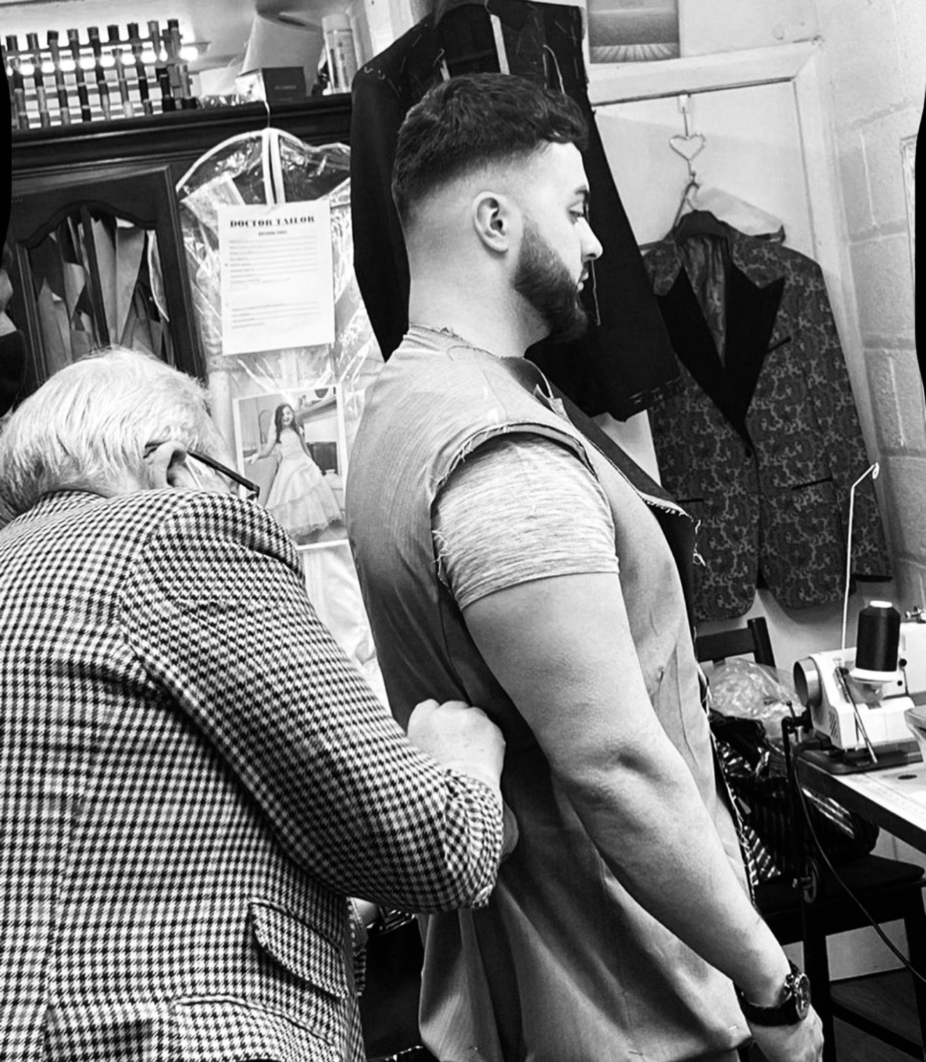 Tailor fitting a waistcoat on a groom at IK Collection in Bradford